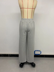 Detail shot of the elastic V-waistband on light grey wide-leg trousers for women