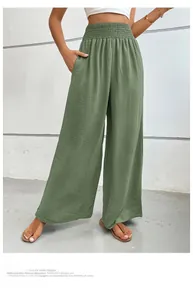 Detail view of olive green high-waisted wide-leg trousers with textured fabric and elastic waist