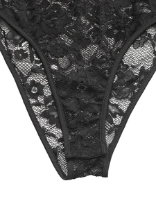 Détail macro du tissu en dentelle florale sur un body noir avec bordures élastiques