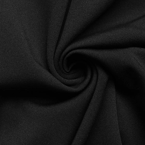 Close-up of premium black fabric with subtle texture and soft draping for elegant dresses