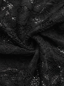 Vue macro d'un tissu en dentelle noire élégante avec des motifs floraux et une texture fine