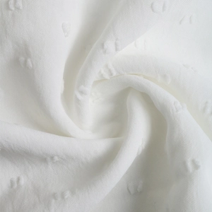 Detailed macro view of white Swiss dot textured lace fabric with embossed floral patterns