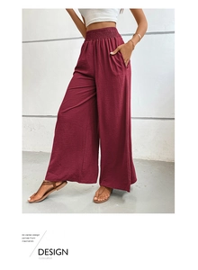 Detail showing high-waisted elastic smocked waist and textured fabric on burgundy wide leg pants
