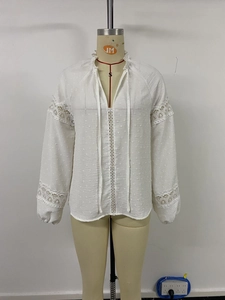 Detail of white dobby shirt featuring crochet lace inserts and a ruffled drawstring neckline