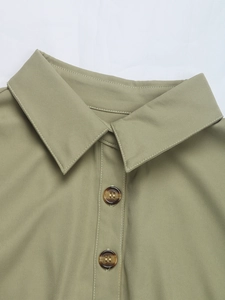 Detail eines olivgrünen Hemdkleids mit Twill-Textur und Knöpfen in Schildpatt-Optik