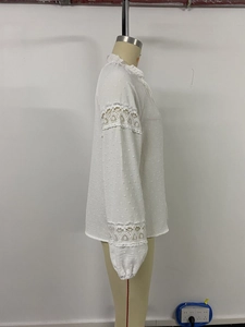Detail of elegant white lace stitching and textured jacquard dots on the long sleeve shirt