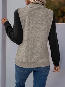 Detail eines Sweatshirts mit kontrastierenden Ärmeln, halbem Reißverschluss und grauer Textur