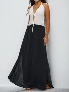 Close-up of black high-waisted maxi skirt featuring side button details and a stylish slit