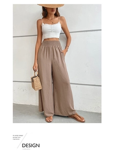Détail d'un pantalon texturé à taille haute avec ceinture élastique et poches latérales