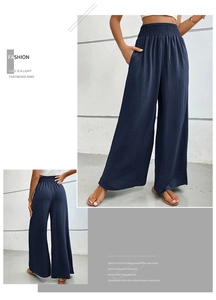 Detail of high waisted wide leg trousers in navy blue with smocked elastic waistband