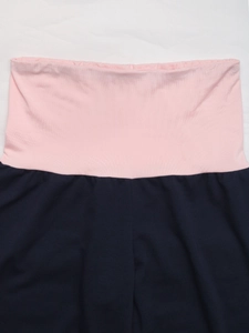 Détail de la taille élastique rose sur le pantalon large contrasté bleu marine