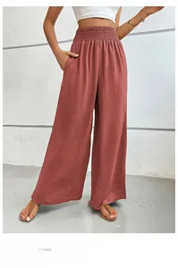 Macro shot of high-waist pleated wide-leg trousers with elastic waistband and side pockets