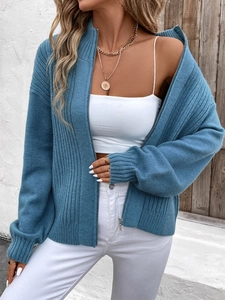 Detail view of blue knit cardigan with vertical texture, silver zipper, and stand collar