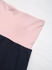 Détail de la taille en tricot rose et coutures contrastées marine du pantalon large