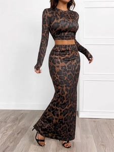 Detail of leopard print crop top and high waist split skirt on a model in a bright room