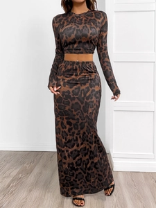 Detail of leopard print fabric texture on long sleeve top and high waist slit skirt set