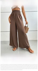 Detail of high waist textured elastic waistband on brown wide leg summer trousers