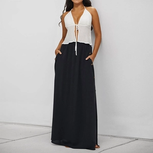 Women black maxi skirt with buttons and pockets paired with a white halter neck top