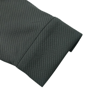 Detailed close-up showing the charcoal grey textured fabric and stitching of the jacket sleeve