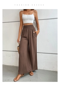 Détail de la taille haute froncée et texture lin sur ce pantalon large marron