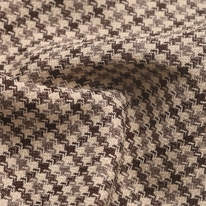 Close-up detail of classic houndstooth woven fabric in brown and beige tones