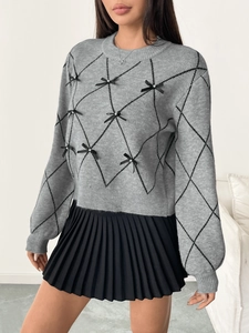 Detail of gray knit sweater featuring black diamond patterns and small satin bows