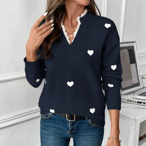 Detailed view of the V-neck lace trim and white heart patterns on the blue knitted sweater