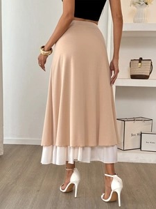 Detail view of beige A-line midi skirt with white ruffled hem and button decorative layer