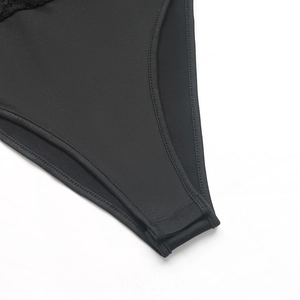 Detail view of the black bodysuit with snap button closure and delicate lace trim