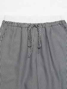 Dettaglio dell'elastico in vita e della coulisse a righe sui pantaloni a righe bianche e nere