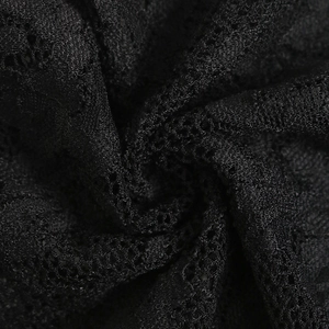 Macro shot of intricate black lace patterns and breathable mesh texture on the bodysuit