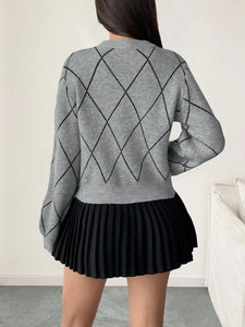 Detail of grey argyle knit sweater back paired with black pleated mini skirt
