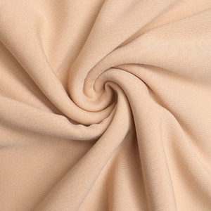 Detail of light beige knitted fabric with soft ribbed texture and elegant drape effect