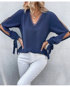 Detail der dunkelblauen V-Ausschnitt Bluse mit Spitzenbesatz und geschlitzten Schleifenärmeln