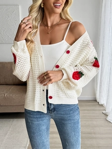 Detail of white crochet knit cardigan with strawberry embroidery and red buttons