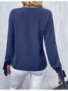 Detailansicht der dunkelblauen Off-Shoulder-Bluse mit eleganten Schleifenbündchen und Spitze