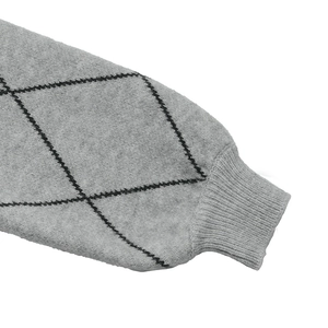 Macro detail of ribbed cuff and black argyle pattern on grey knitted sweater fabric