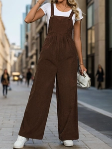 Detail of vintage dark brown corduroy jumpsuit with golden metal buttons and high waist