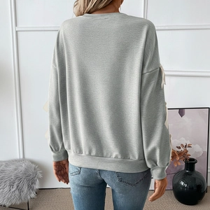 Detail of grey sweatshirt back view with cream bow ties on sleeves and dropped shoulders