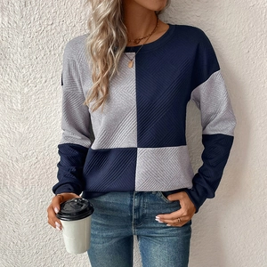 Detail of blue and grey patchwork sweatshirt featuring unique textured waffle fabric