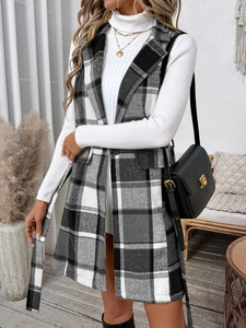 Detail of black and white plaid vest with waist belt and classic lapel collar