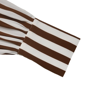 Détail de la manche de chemise à rayures marron et blanc avec poignets froncés et coutures