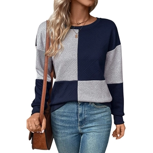 Detail of navy blue and light grey patchwork knitted pullover with textured pattern
