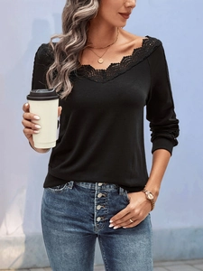 Close-up of black V-neck top featuring delicate lace trim on the neckline and long sleeves