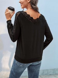 Detail of elegant black long sleeve top with deep V-neck lace patchwork on the back