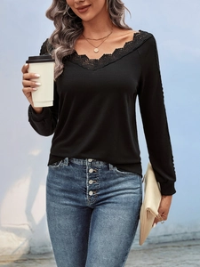 Detail of elegant black V-neck top with intricate lace trim and long cuffed sleeves