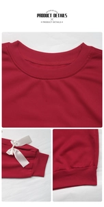Detail view of ribbed crew neck and white satin bow on the sleeve of a red sweatshirt