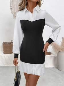 Detail of contrast lapel collar and pleated hem on a black and white long sleeve dress