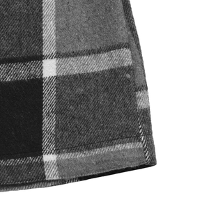 Close-up of black and white plaid wool texture and precise stitching on vest jacket