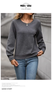 Detail view of the dark grey waffle texture fabric on a casual crewneck sweatshirt